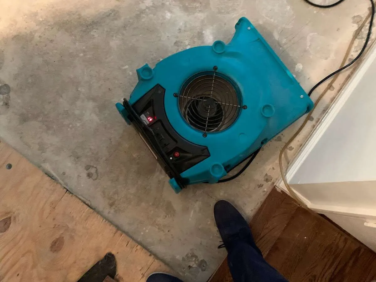 Air mover drying subfloor during Commercial Water Damage Restoration in Hudson
